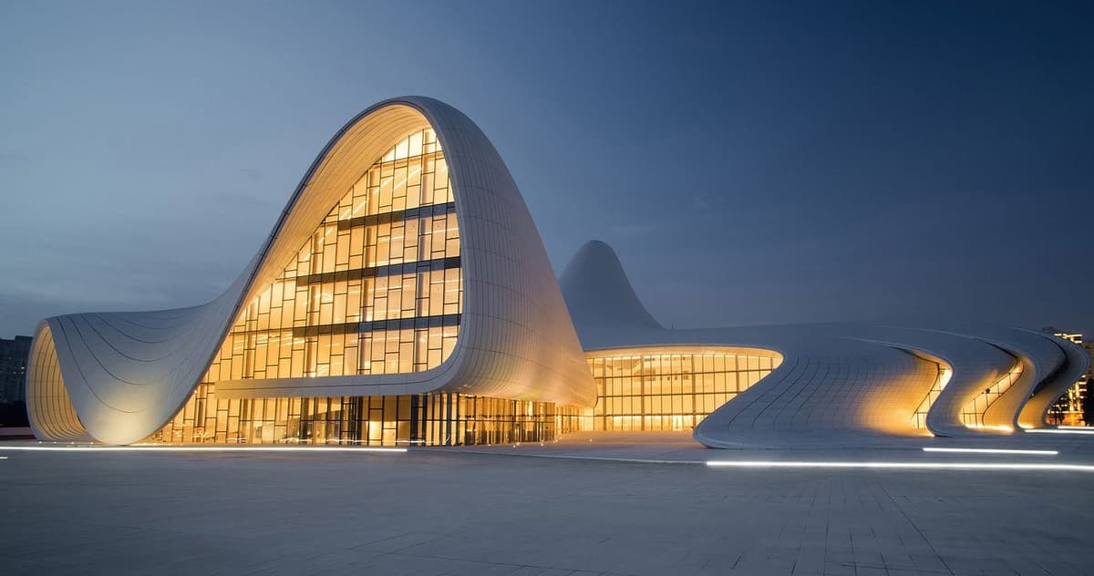 Heydar Aliyev Center de Zaha Hadid Architects iluminado al atardecer